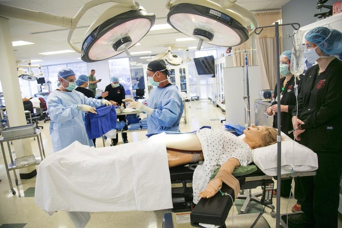 Certified surgical technologist student Travis Stice, left, hands instructor Biff Boggs, center, material for a simulated appendectomy surgery during his clinical final exam at the College of Western Idaho Boise Center last week. CWI wants to move its health science program to the Nampa campus, but defeat of a bond last week will delay that.