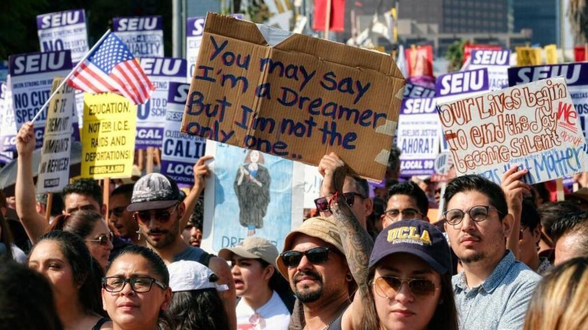 Supporters of the Deferred Action for Childhood Arrivals program, or DACA, chant slogans and hold signs while joining a Labor Day rally in downtown Los Angeles on Monday.