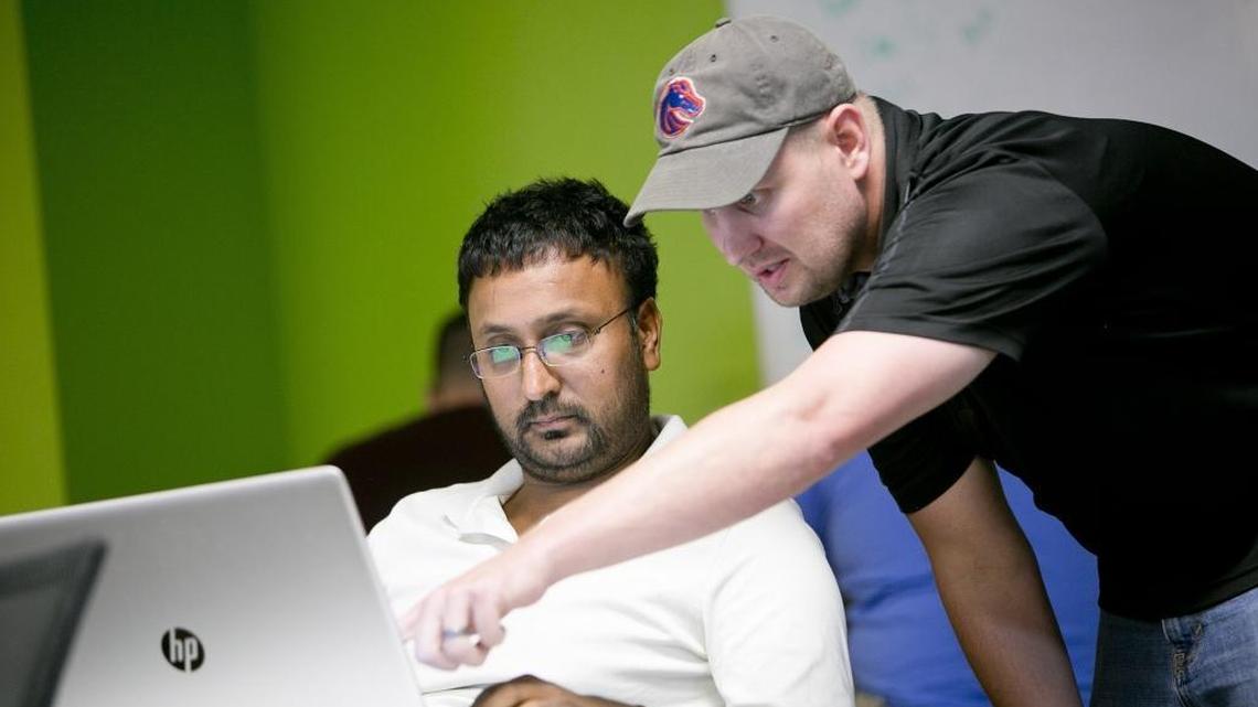 Instructor Matt Overall (right) helps a student with a Javascript exercise during a BoiseCodeWorks bootcamp in September 2015. Such code schools have popped up across the country, offering intensive, “boot-camp” style courses that allow students to get certified in coding programs more quickly than they would by attending college — and in theory, qualifying them for many of the tech jobs that today’s companies have a hard time filling.