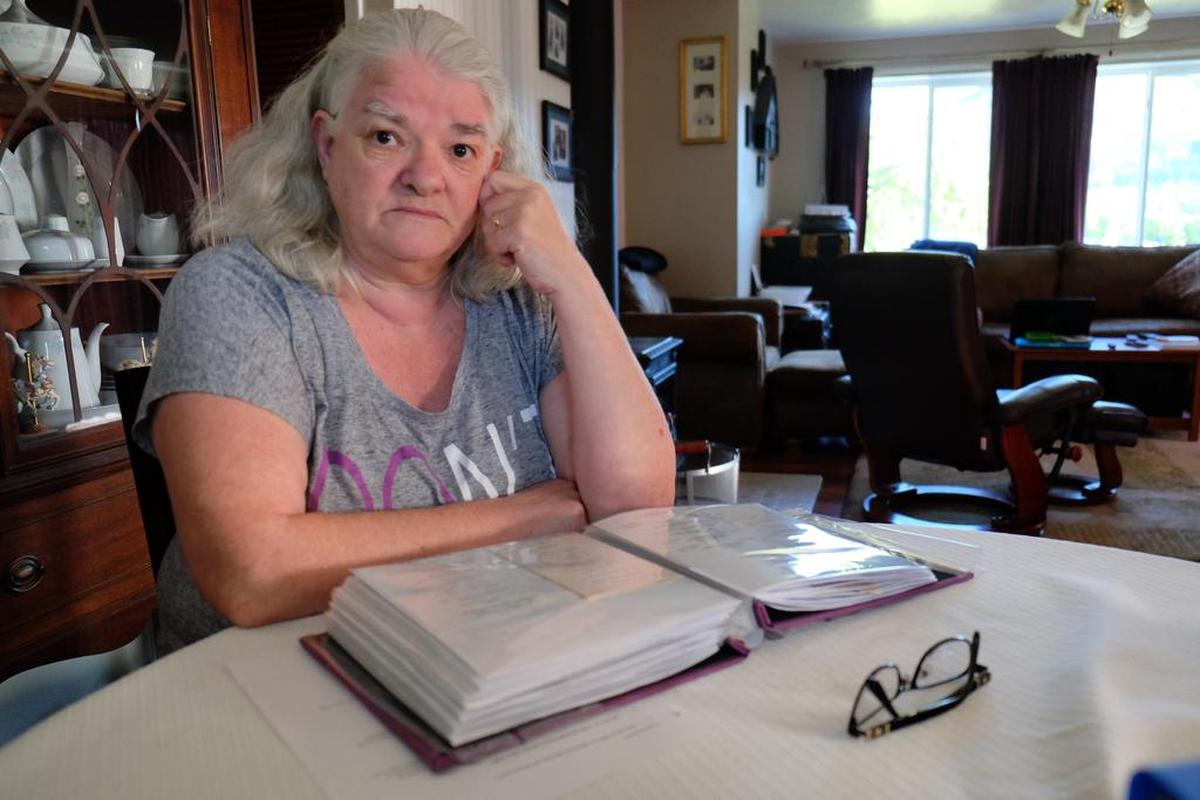 Linda Martin, who left the Followers of Christ church as a teenager, is working to remove faith healing exemptions from Idaho’s child injury laws. In this 2016 photo, she looks through a binder of funeral cards for 138 church members, almost all relatives or acquaintances. About one-quarter of them died before they were 35, and 14 were under 18.