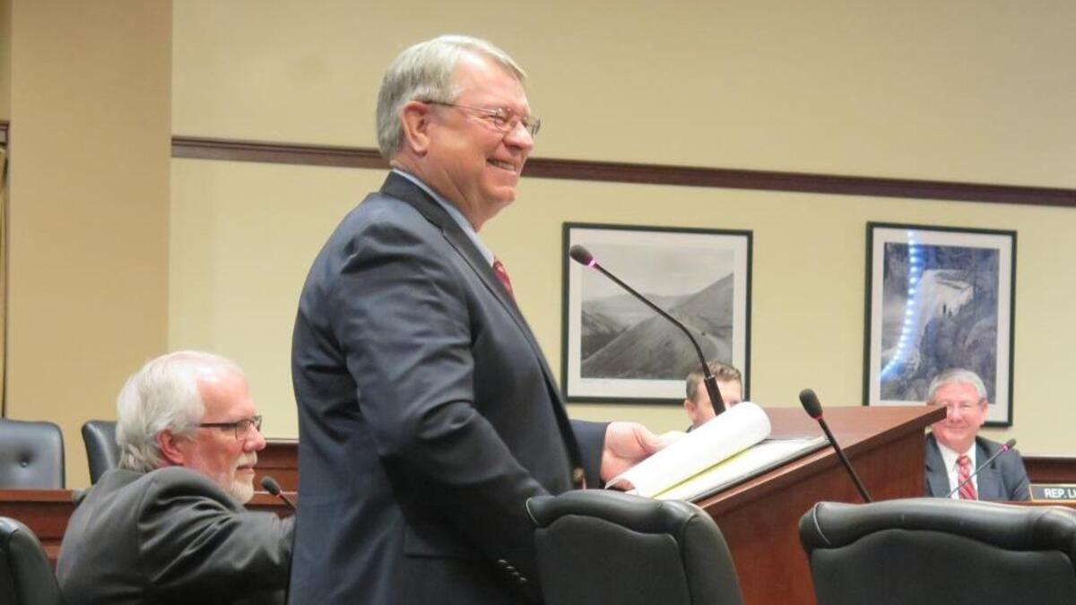 Idaho Secretary of State Lawerence Denney grins as he responds to questions from members of the House State Affairs Committee on Tuesday, Feb. 13, 2018, about campaign finance reform legislation proposed unanimously by an interim legislative committee.