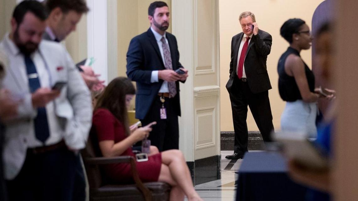 Idaho Sen. Mike Crapo, in background, outside a Senate Republican meeting on health care reform Thursday.