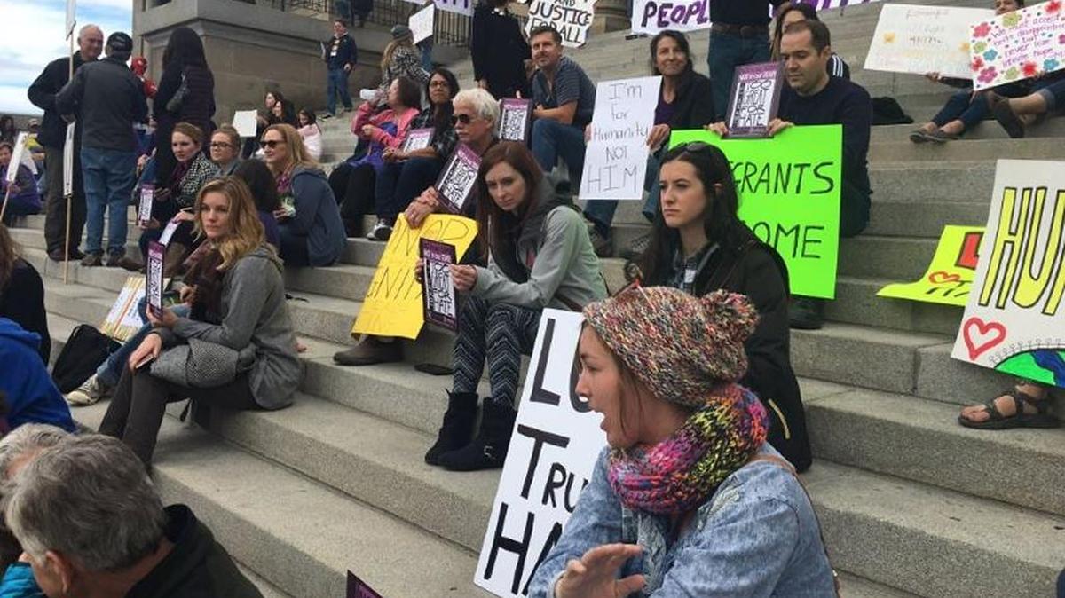 Unity rally attendees sit on the steps of the Idaho Capitol Building on Saturday, Nov. 12.