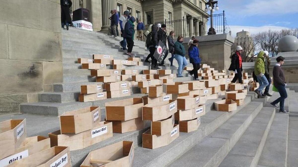 Protesters stacked 183 symbolic child-sized coffins on the Idaho Capitol steps on Monday, calling for Idaho to repeal its faith-healing exemption. That law allows parents to deny their children medical care without civil or criminal liability, even if the children die.