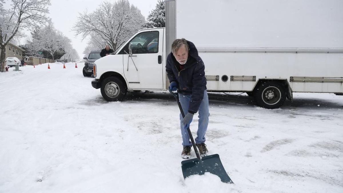 Scott Callen of Callen Construction clears snow around his truck in hopes of getting it safely down the hill Monday morning at East Shenandoah Drive and Pierce Street in east Boise. An extremely slick surface closed Shenandoah.