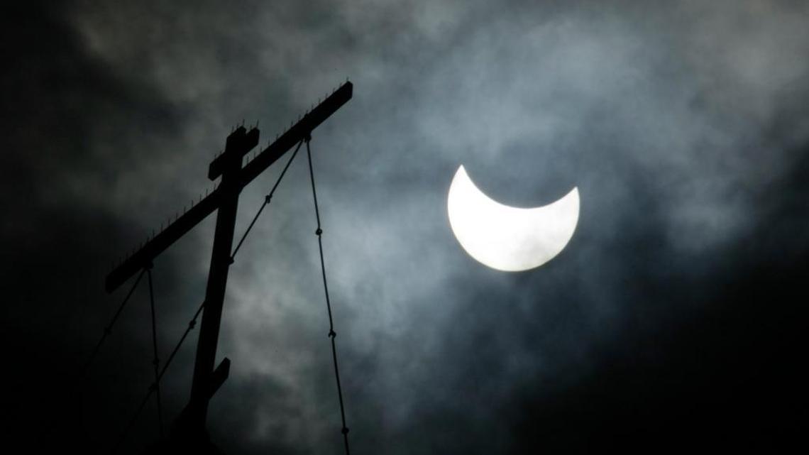 In this photo from Aug. 1, 2008, the moon passes in front of the sun during a total solar eclipse. The cross of St. Basil’s Cathedral is visible at left in Moscow’s Red Square.