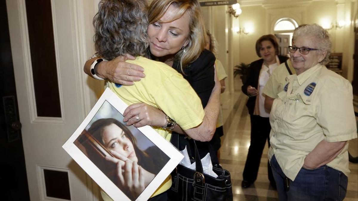 Debbie Ziegler holds a photo of her late daughter, Brittany Maynard, as she receives congratulations from Ellen Pontac, left, after a right-to die measure was approved by the state Assembly in Sacramento, Calif., last year and became law this week. California is the fifth state to allow terminally ill patients to legally end their lives using doctor-prescribed drugs after Gov. Jerry Brown announced Monday, Oct. 5, 2015 he had signed one of the most emotionally charged bills of the year. (AP)