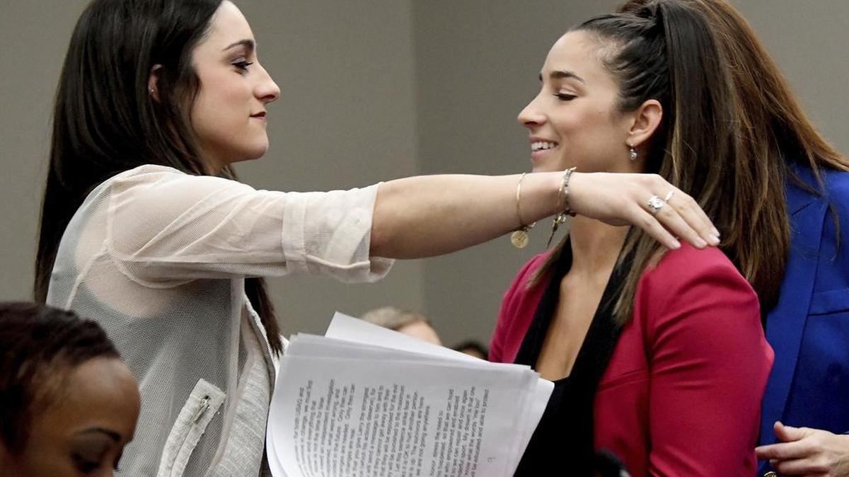 Olympic gold medalists Aly Raisman, right, and Jordyn Wieber embrace in court in Lansing, Mich., Jan. 19 during the sentencing for former sports doctor Larry Nassar, who pled guilty to multiple counts of sexual assault.