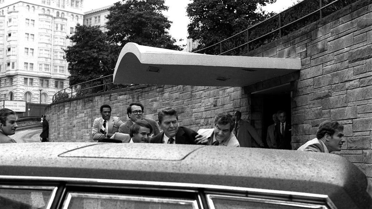 On March 30, 1981, President Ronald Reagan is shoved into a limousine by Secret Service agents after being shot outside a Washington hotel.