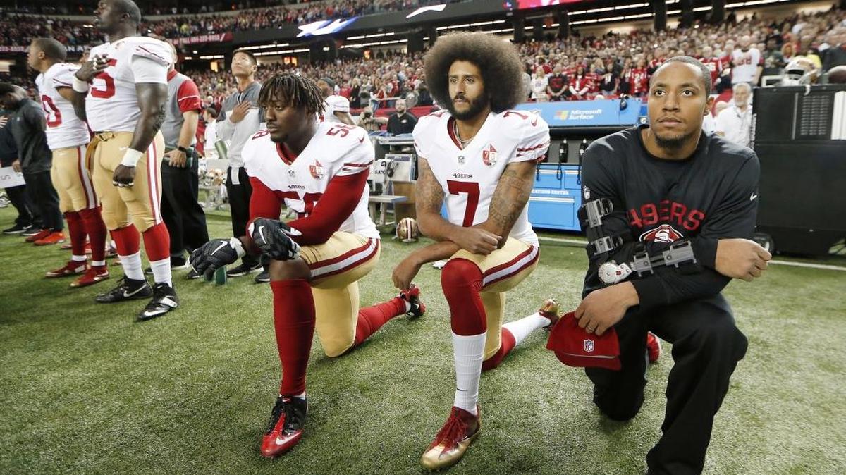 San Francisco 49ers quarterback Colin Kaepernick, center, kneels during the playing of the national anthem before a game against the Atlanta Falcons in 2016.