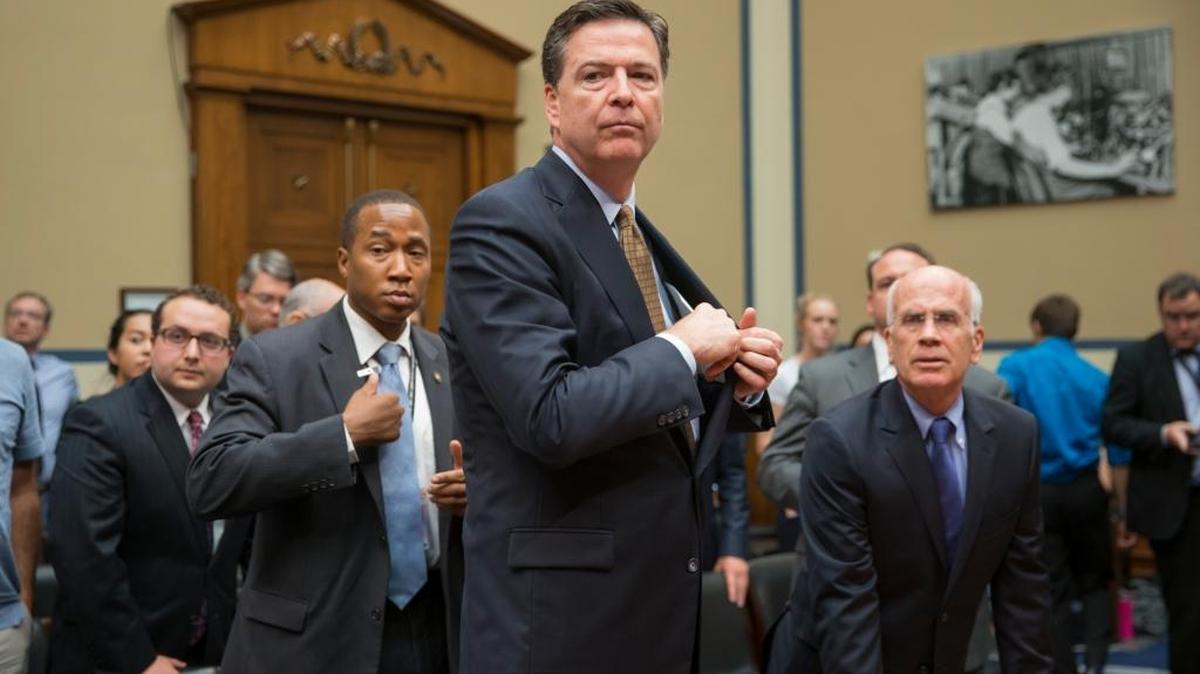 FBI Director James Comey gets ready to testify at a House hearing.