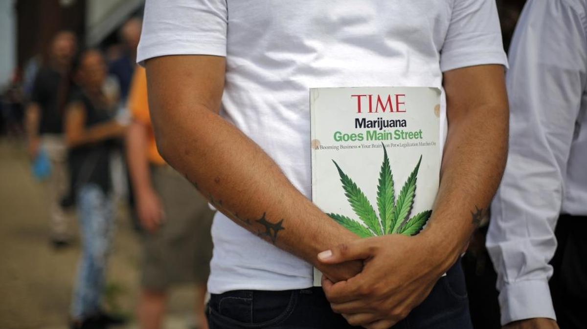 A job applicant holds a Time magazine while waiting in line in McKeesport, Pa., to attend a medical marijuana job fair July 27. One of the first Pennsylvania’s medicinal cannabis processor, PurePenn, expects to hire 50 full-time employees in the next 10 months.