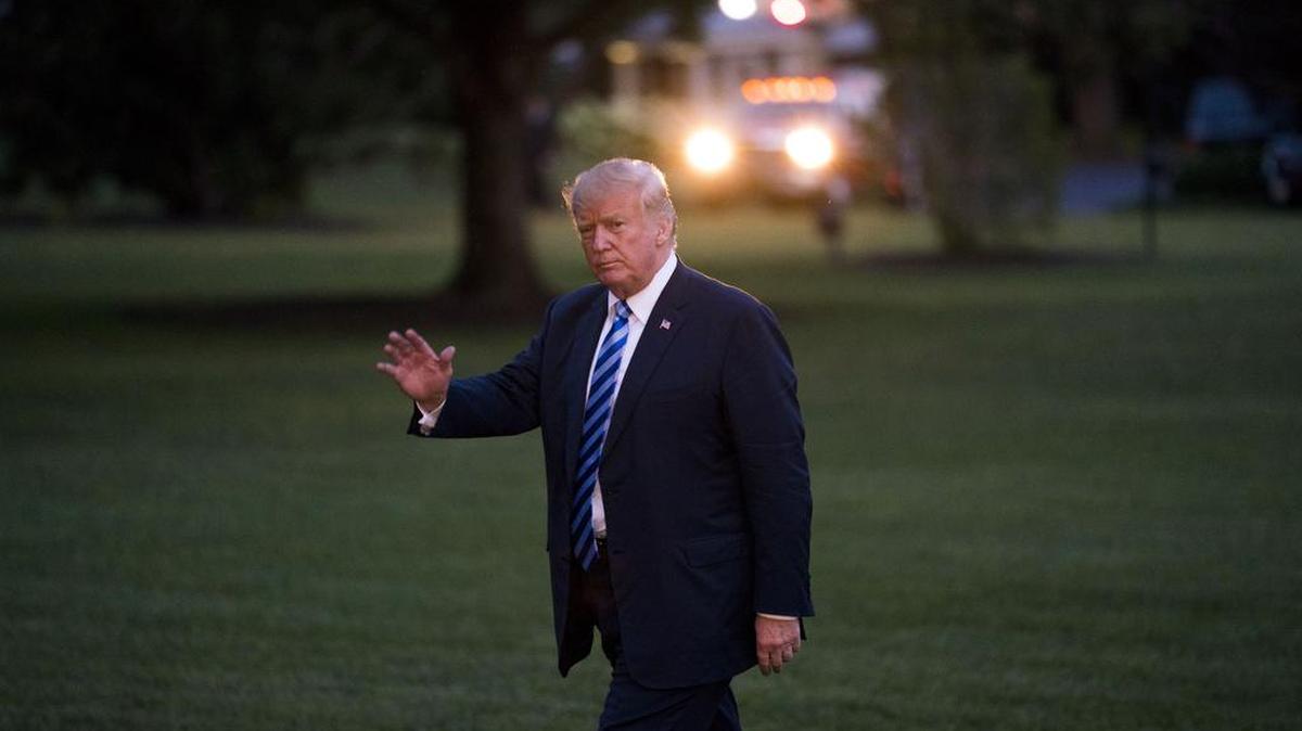 President Donald Trump walks toward the White House.