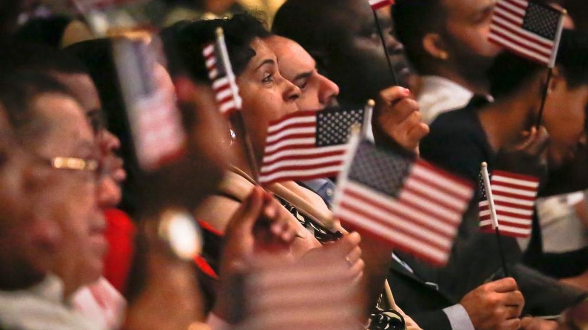 New U.S. citizens wave flags during a special Flag Day naturalization ceremony at the New York Historical Society.