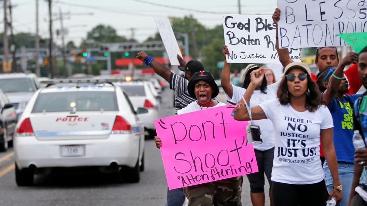 People demonstrate in the street as police cars pass outside the Triple S convenience store during a rally after Alton Sterling, a black man, was shot and killed Tuesday, in Baton Rouge, La., Wednesday, July 6, 2016. The U.S. Justice Department opened a civil rights investigation Wednesday into the video-recorded police killing of Sterling, who authorities say had a gun as he wrestled with two white officers on the pavement outside a convenience store. (AP)