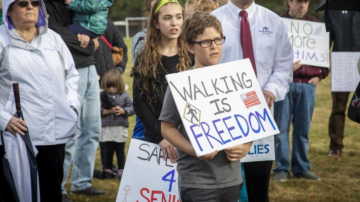 Mark Conde, 10, and his family join a group of neighbors, activists and concerned residents for a silent walk in honor of Frances and Bob Goar, who were killed in a pedestrian crosswalk earlier this year.