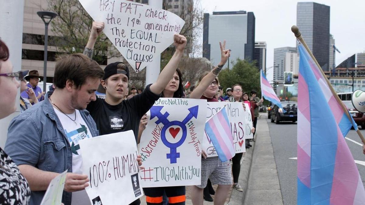 Demonstrators protesting passage of legislation limiting bathroom access for transgender people stand in front of the Charlotte-Mecklenburg Government Center in Charlotte, N.C., March 31, 2016. The Transgender bathroom debate continues after President Donald Trump rescinds some protections provided by the Obama Administration. (AP)