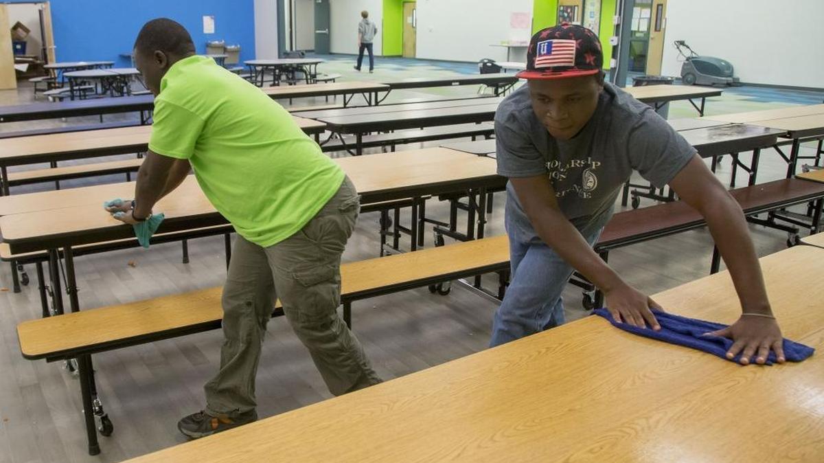 Joli Ramadhan, right, and Bonane Basengelele clean tables after lunch hour at Sage International School in Boise Thursday Nov. 10, 2016. The two men are refugees from the Congo where both lost members of their family as young boys and fled the violence. The school helps place refugees in jobs through various local programs.