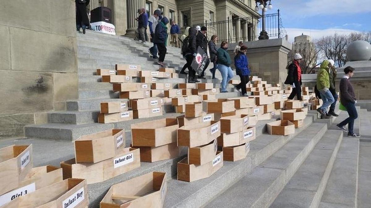 Protesters stacked symbolic child-sized coffins at the Idaho Capitol in February 2018, seeking repeal of a faith-healing exemption for parents who deny their children medical care.