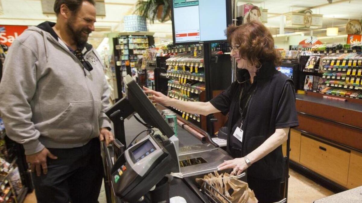 Cashier Saundra Miller at the Albertsons at State and 16th Streets in Boise helps customer Darren Sand in March 2013.