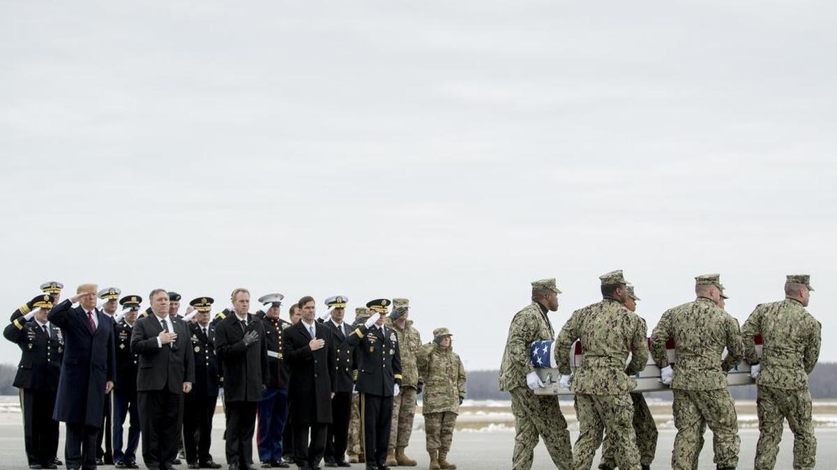 President Donald Trump and others watch as a U.S. Navy carry team moves a transfer case containing the remains of Scott A. Wirtz, one of the American victims of a suicide bomber in Syria last week.