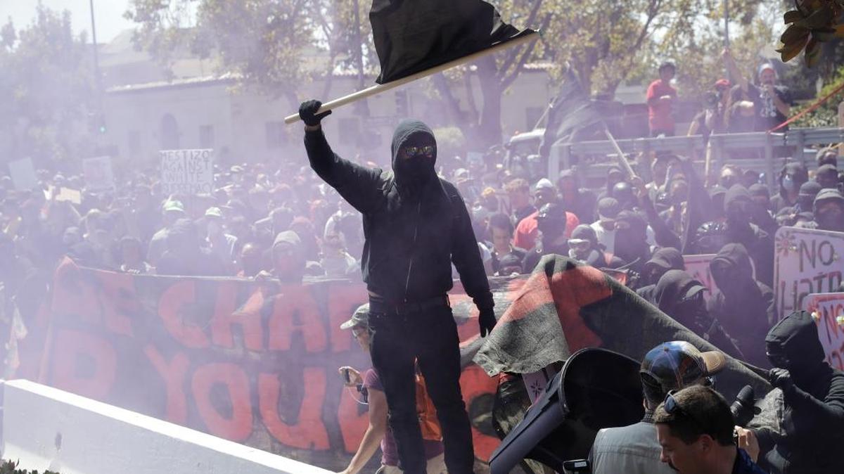 An anti-fascist demonstrator jumps over a barricade during a free speech rally Aug. 27 in Berkeley, Calif. Several thousand people converged in Berkeley Sunday for a “Rally Against Hate” in response to a planned right-wing protest that raised concerns of violence and triggered a massive police presence. Several people were arrested for violating rules against covering their faces or carrying items banned by authorities.