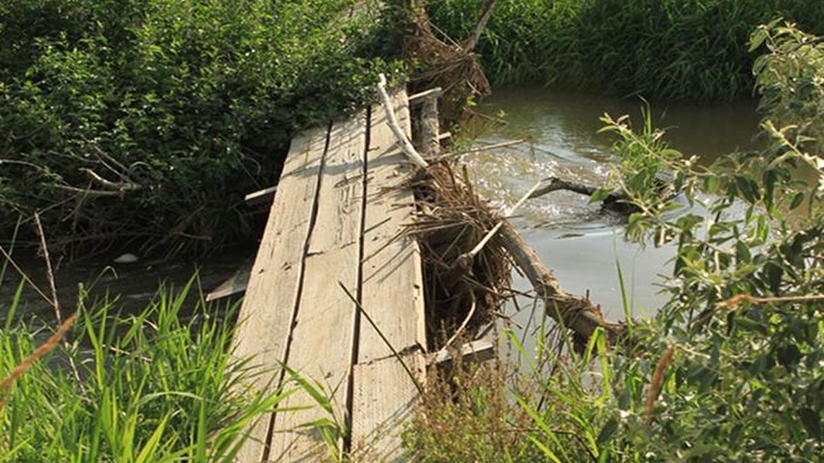 During the spring flood, debris piled up against this footbridge, eventually knocking it off its foundation. A second footbridge also suffered extensive damage.