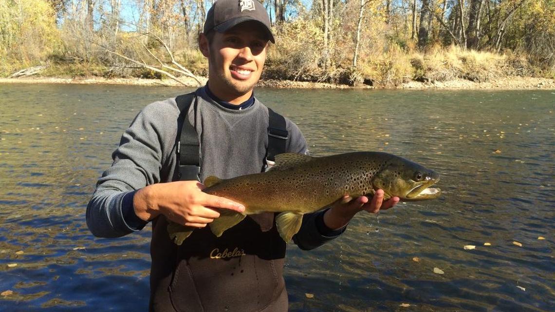 Jordan Rodriguez holds one of the brown trout captured during a fish survey on the Boise River.