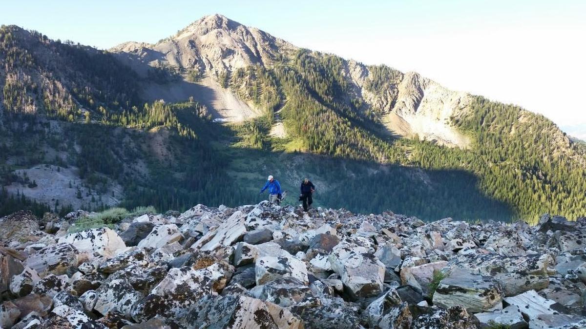 “Outdoor Idaho” videographer Jay Krajic, right, and his volunteer tripod-carrier, Terry Lee, ascend out of Big Basin toward Old Hyndman Peak as the sun rises on an August television shoot.