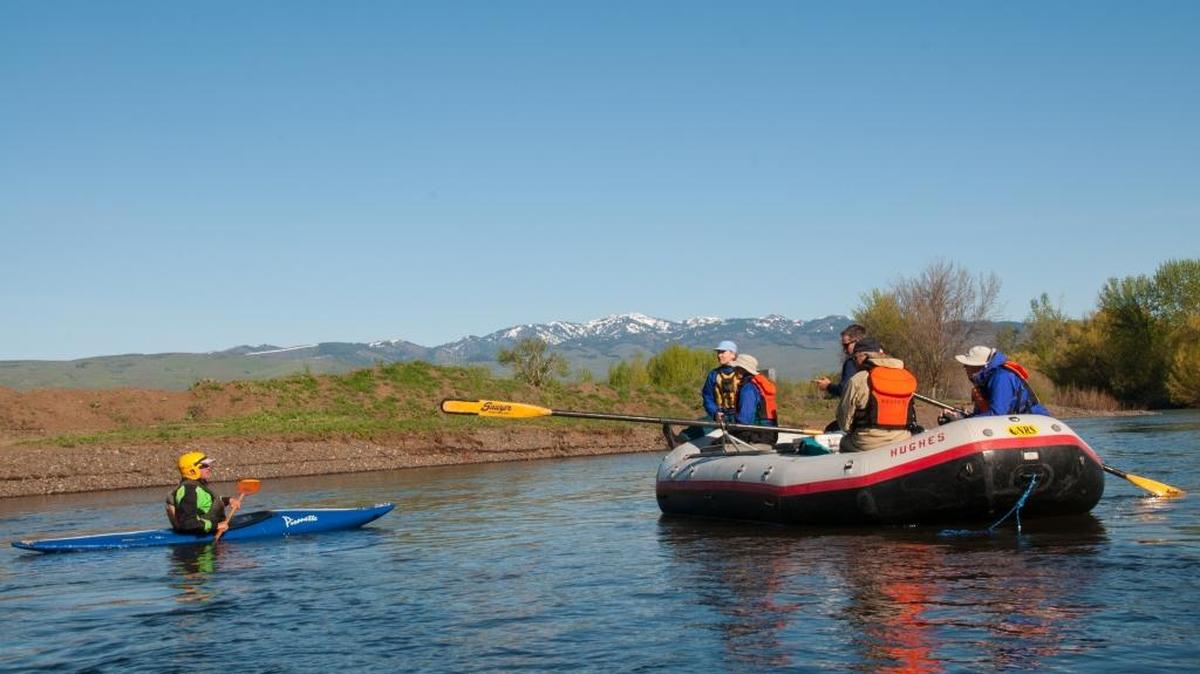 Kayaker Roger Rosentreter pauses to chat with some rafters during a float trip down the Weiser River.