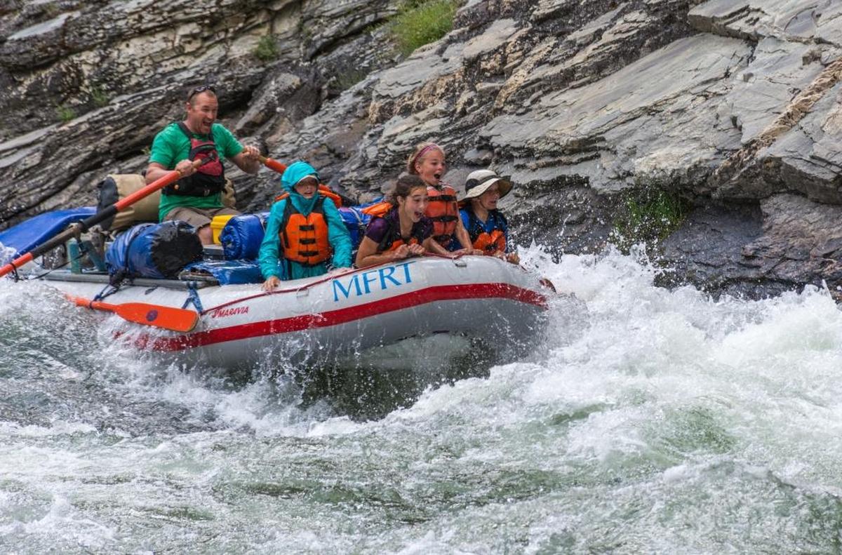 Alex Lanza, the girl standing tallest in the front of the raft, enjoys the waves on the Middle Fork of the Salmon River during a family rafting-kayaking trip in 2015.
