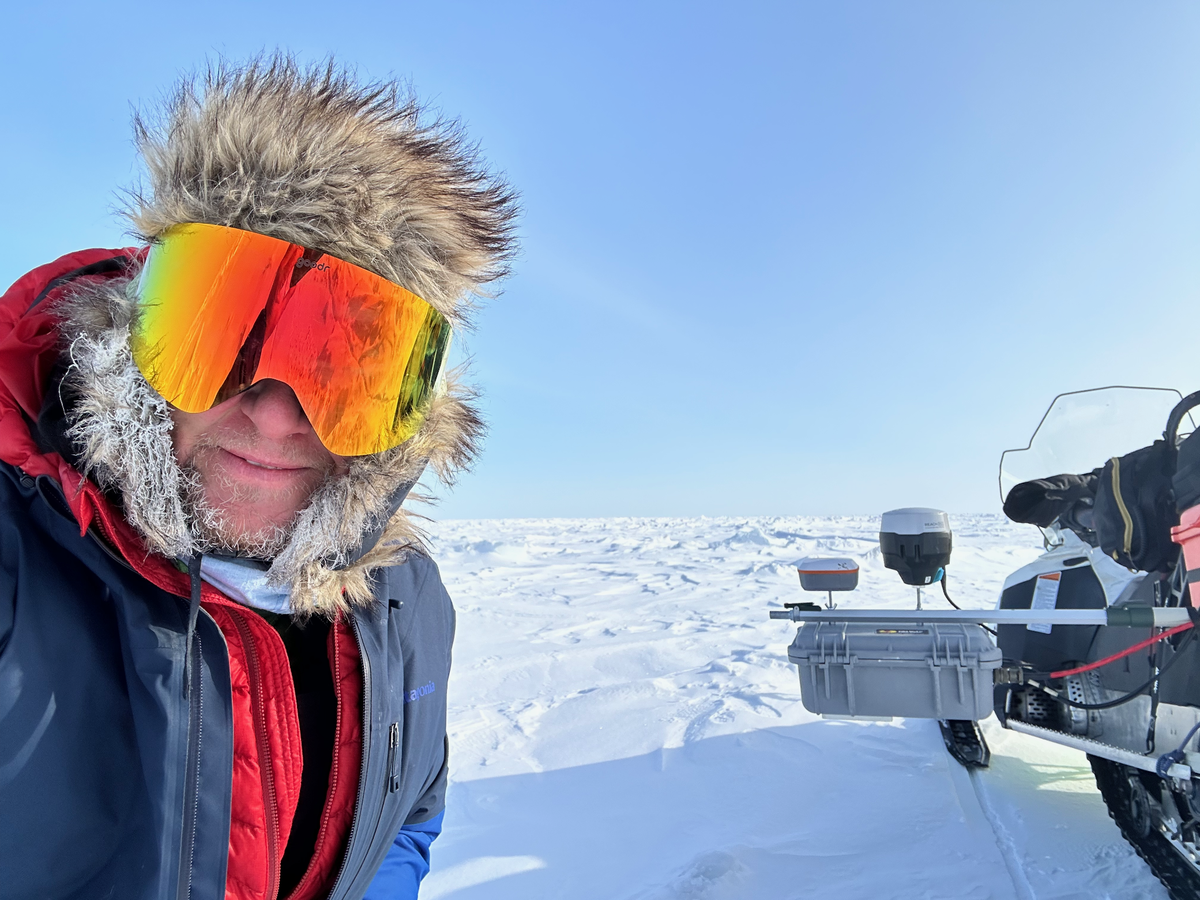 Boise State University associate professor Hans-Peter Marshall poses at the the field site where researchers are studying snow and ice depth, alongside a radar system used for research and mounted on a snow mobile, in April 2024, Beaufort sea ice, near Utqiagvik, Alaska.