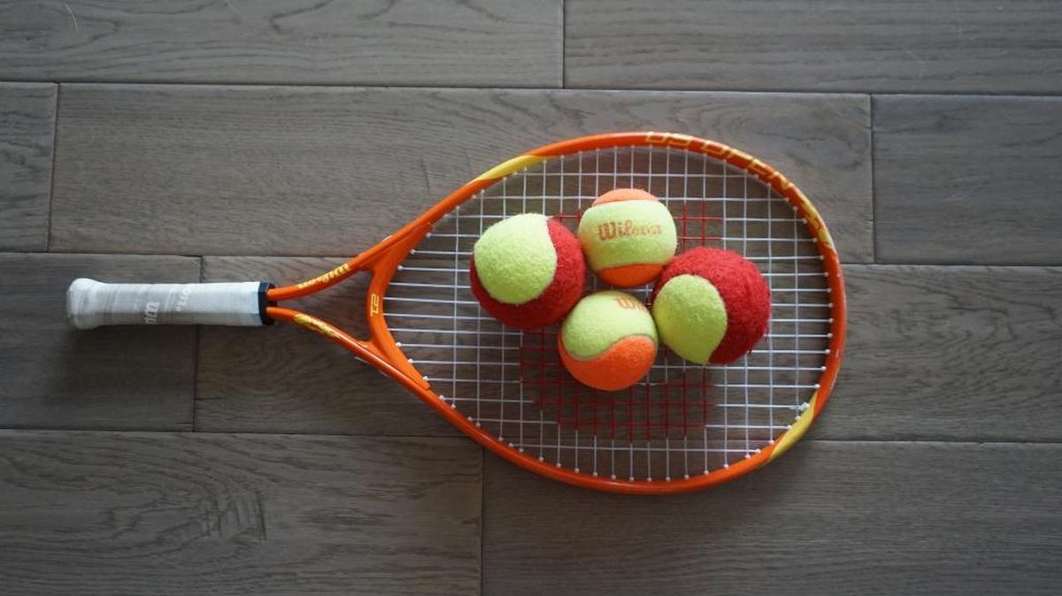 A 21-inch racket with red and orange balls for 10 and Under Tennis.