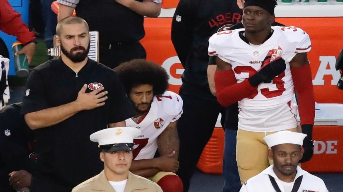 San Francisco 49ers quarterback Colin Kaepernick, middle, kneels during the national anthem before the team’s preseason game against the San Diego Chargers on Thursday in San Diego.