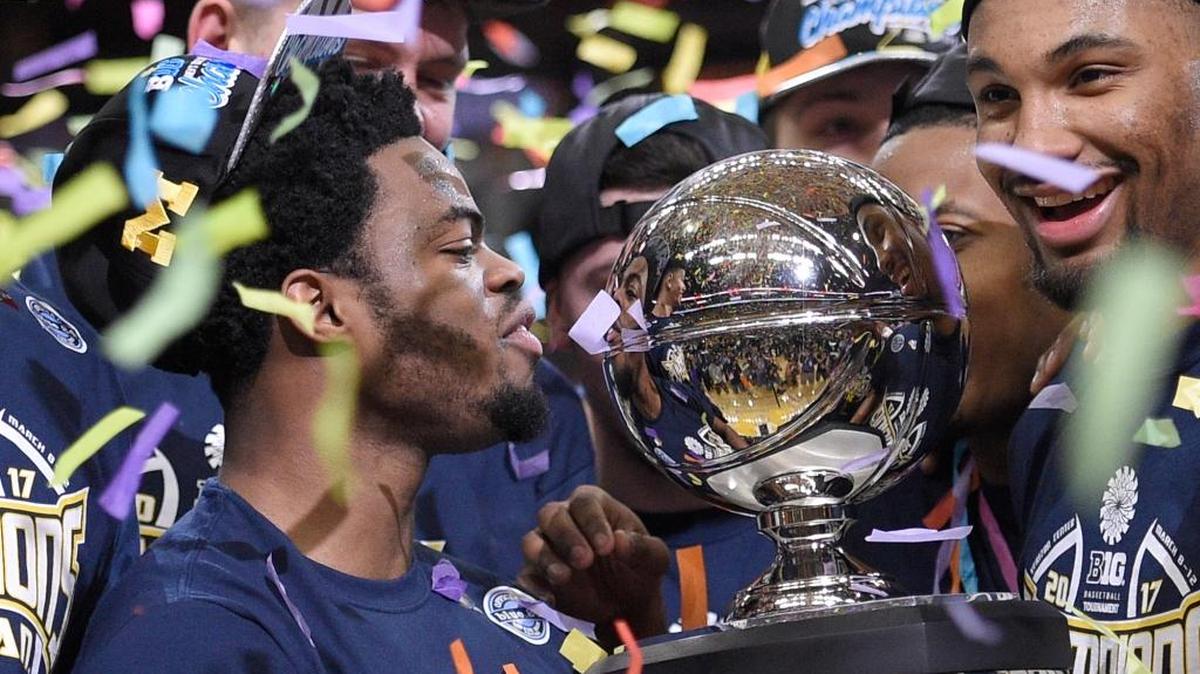 MICHIGAN TAKES BIG TEN Michigan’s Derrick Walton Jr., left, looks at the trophy as he and teammates celebrate after defeating Wisconsin 71-56 in an NCAA college basketball game for the Big Ten tournament title, Sunday, March 12, 2017, in Washington.