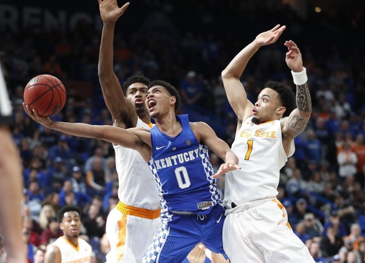 Kentucky's Quade Green (0) drives between Tennessee’s Kyle Alexander, left, and Lamonte Turner (1) on Sunday in St. Louis.