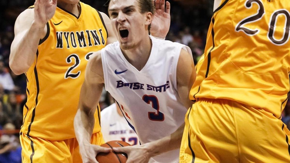 Boise State’s Anthony Drmic moves the ball between Wyoming’s Larry Nance Jr. (22) and Nathan Sobey (20) during the second half of a Jan. 11, 2014, game in Boise on Saturday. Wyoming defeated Boise State 52-50.