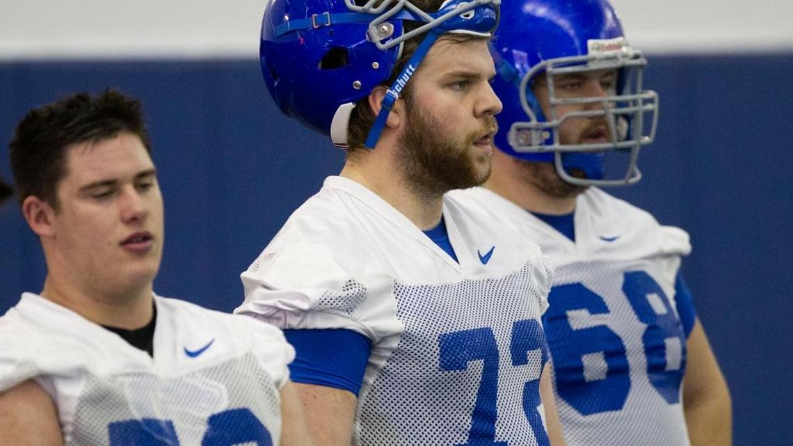 Boise State ofensive lineman Will Adams, center, looks on during the Broncos’ first spring practice.