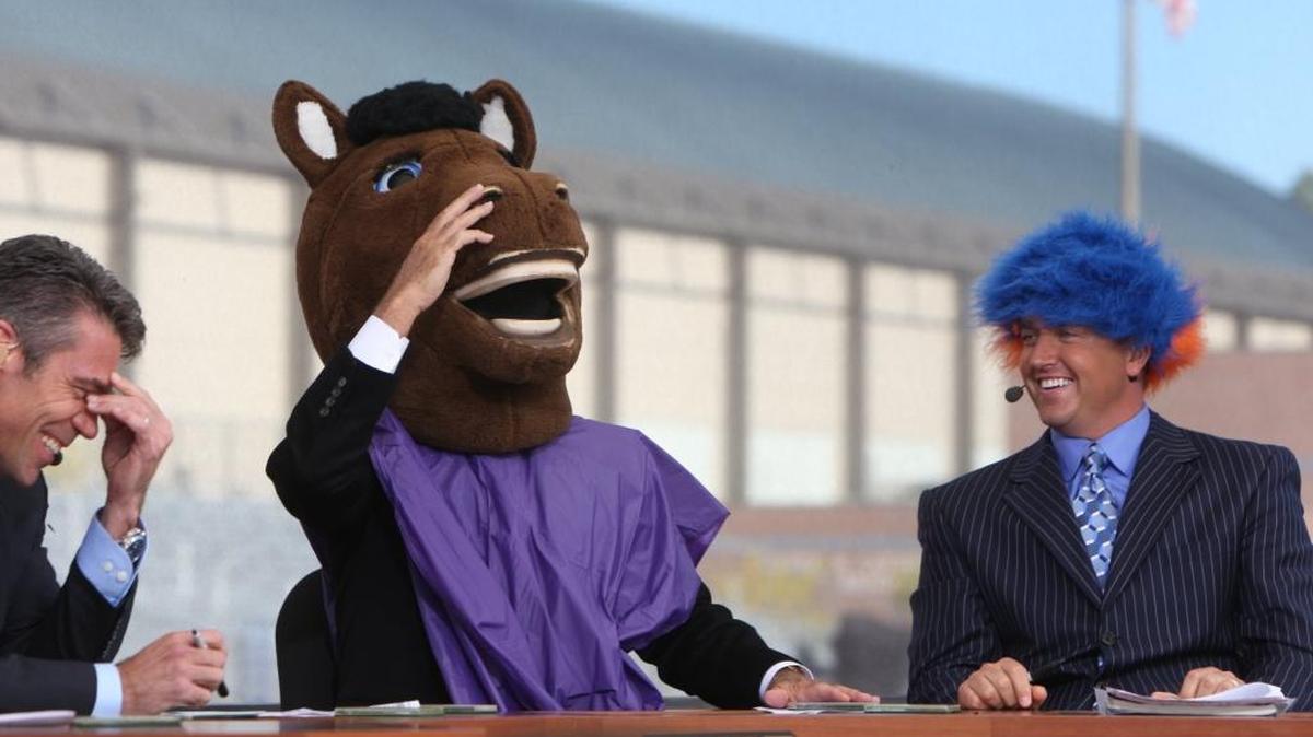 ESPN analyst Lee Corso dons a Bronco head while Kirk Herbstreit wears a blue-and-orange wig, much to the amusement of Chris Fowler (left) during the “College GameDay” show in 2010 in Boise.