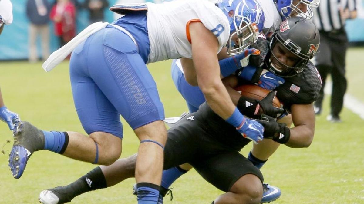 Boise State defensive linemen Kamalei Correa (8) and Tyler Horn tackle Northern Illinois running back Jordan Huff in the Poinsettia Bowl on Wednesday at Qualcomm Stadium in San Diego.