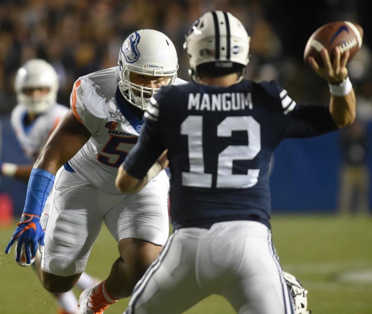 Boise State’s Emmanuel Fesili closes in on BYU quarterback Tanner Mangum on Friday night at LaVell Edwards Stadium in Provo, Utah.