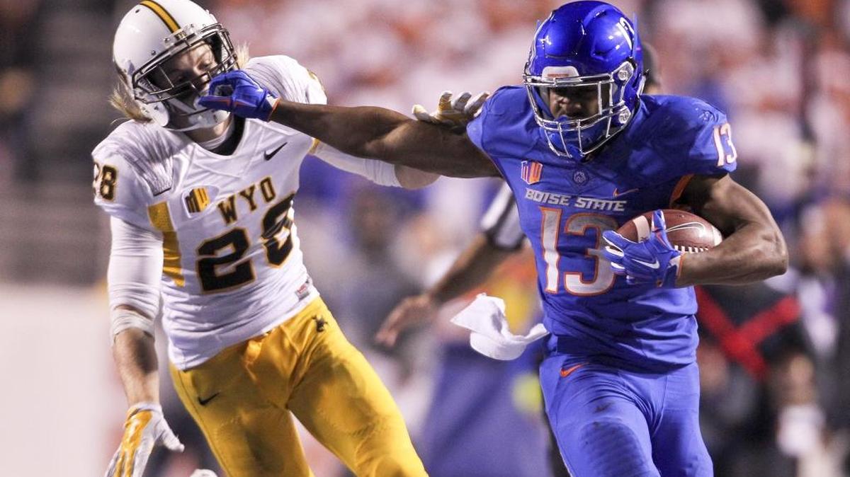 Boise State running back Jeremy McNichols (13) stiff arms Wyoming safety Andrew Wingard (28). Boise State defeated Wyoming 34-14 at Albertsons Stadium in Boise, Idaho. Saturday, Oct. 24, 2015.
