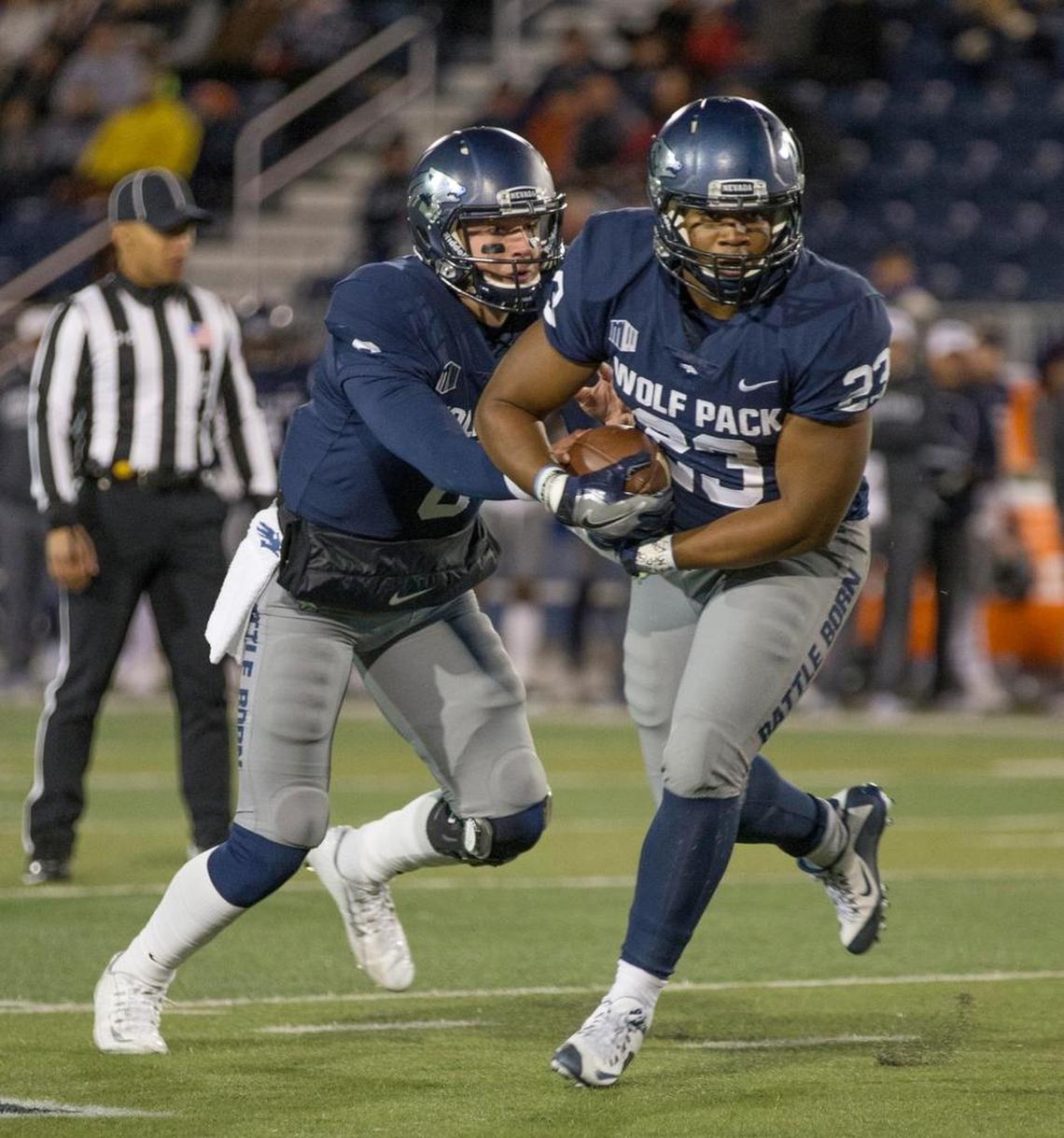 Nevada quarterback Ty Gangi, left, hands the ball off to running back Kelton Moore in the first half Oct. 20 against Air Force in Reno, Nev.