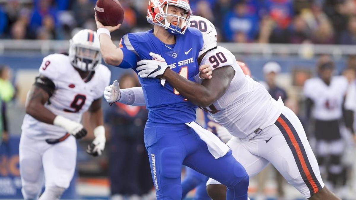 Boise State quarterback Brett Rypien gets hit during a throw by Virginia defensive end Steven Wright on Friday night at Albertsons Stadium.