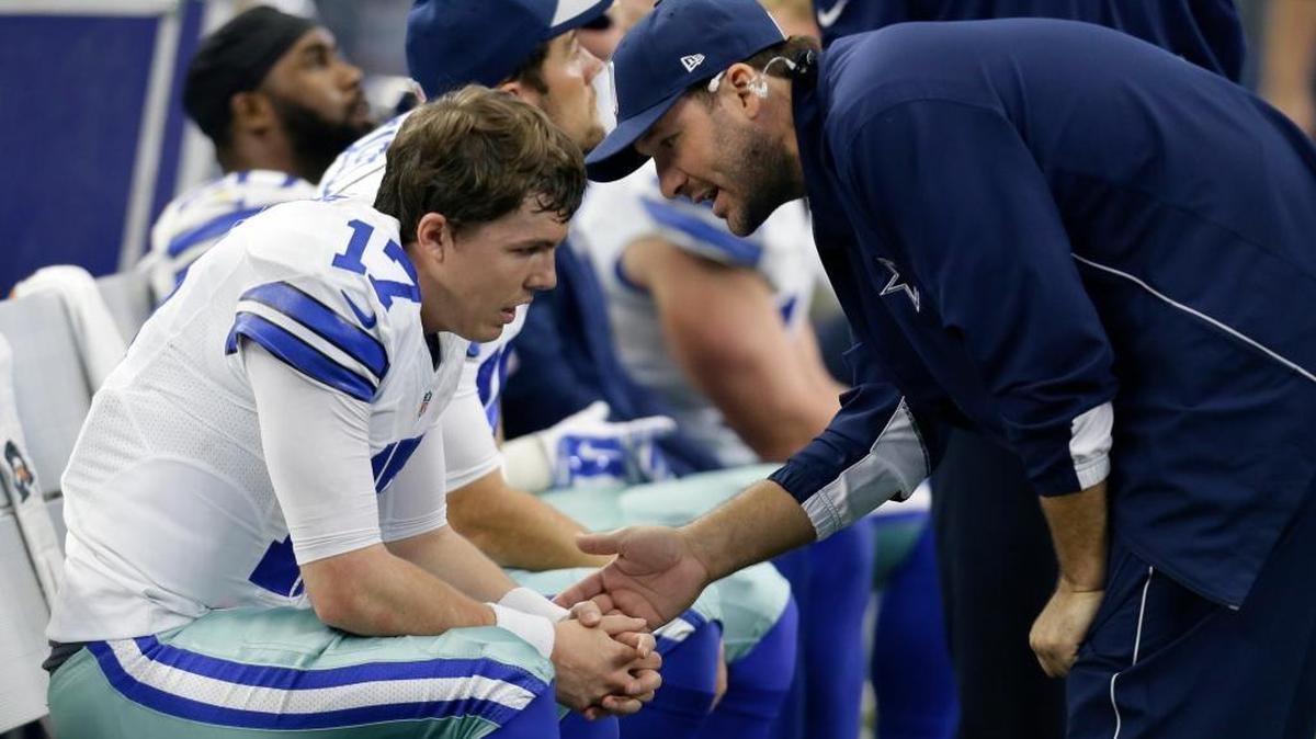 Cowboys quarterback Kellen Moore talks with injured starter Tony Romo during Sunday’s loss to the Redskins.