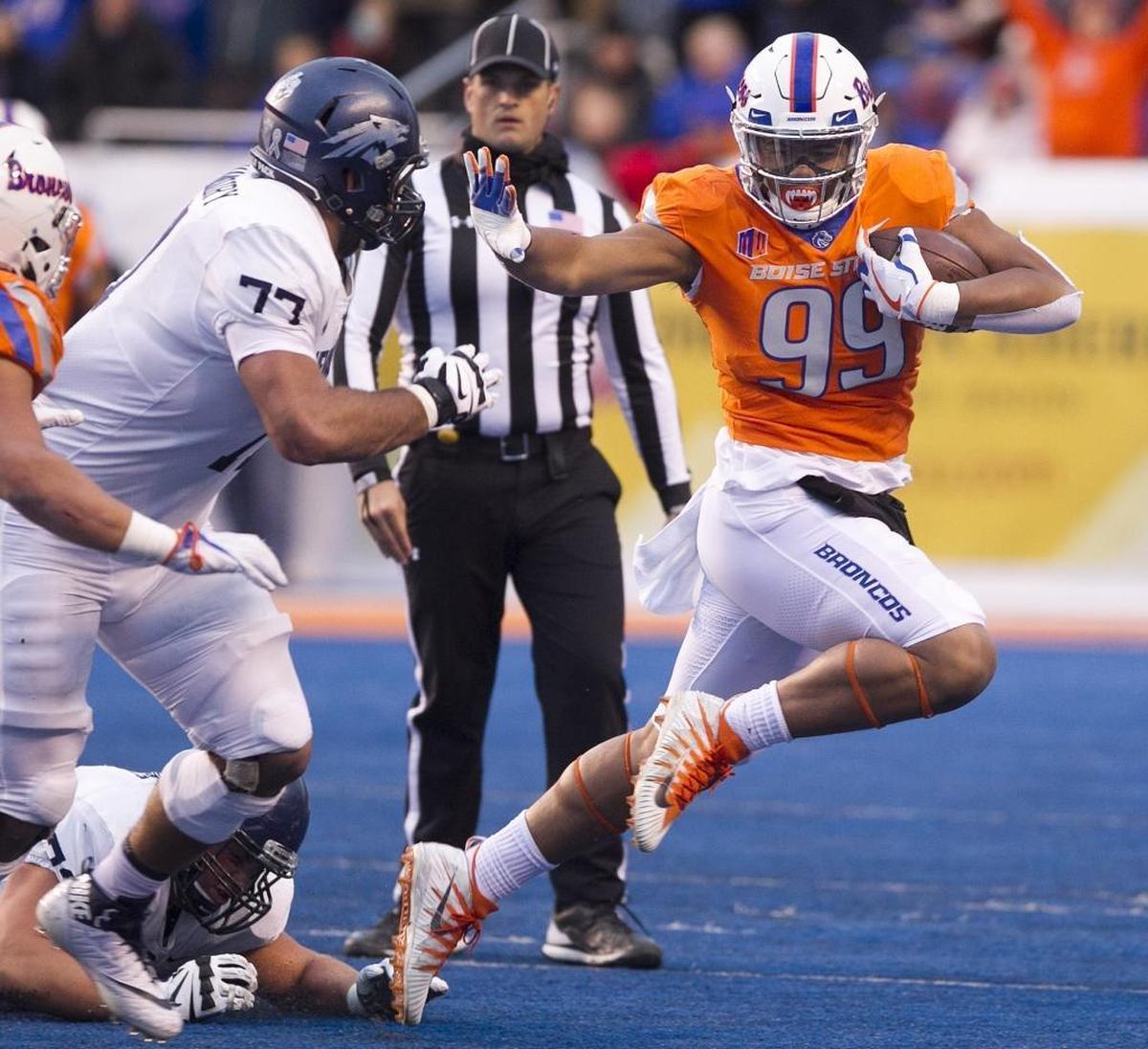 Boise State defensive end Curtis Weaver stiff-arms Nevada offensive lineman Ziad Damanhoury after making a second-quarter interception last Saturday at Albertsons Stadium in Boise.