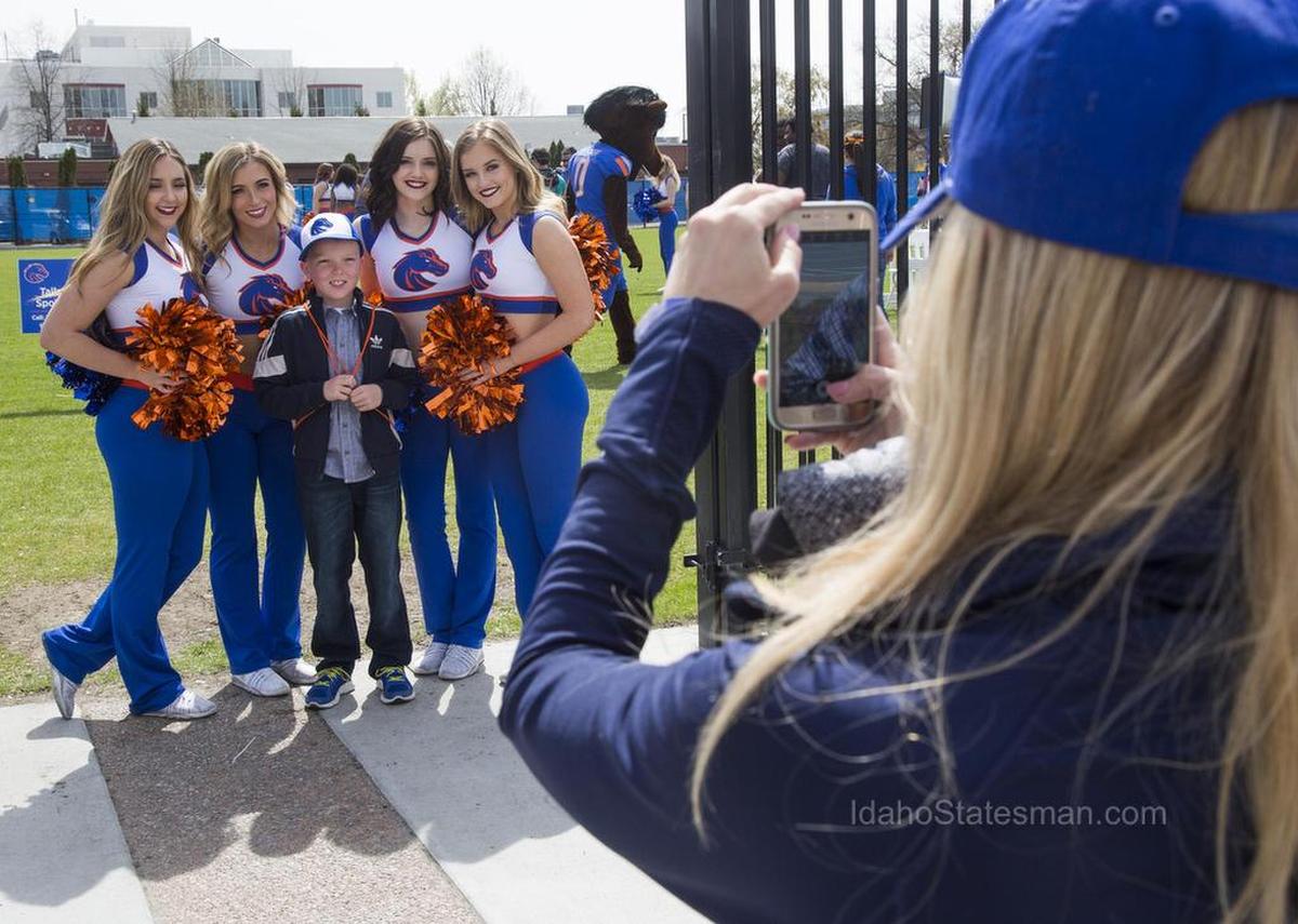 Boise State cheerleaders pose for pictures with fans before the start of the annual Spring Game Saturday, April 14, 2018 at Albertsons Stadium in Boise.