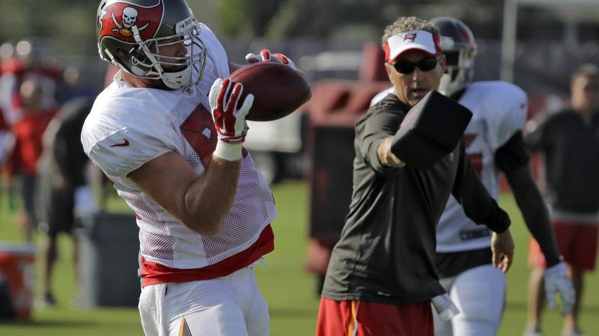 Tampa Bay tight end Brandon Myers makes a catch as offensive coordinator Dirk Koetter attempts to knock it away during Buccaneers training camp.