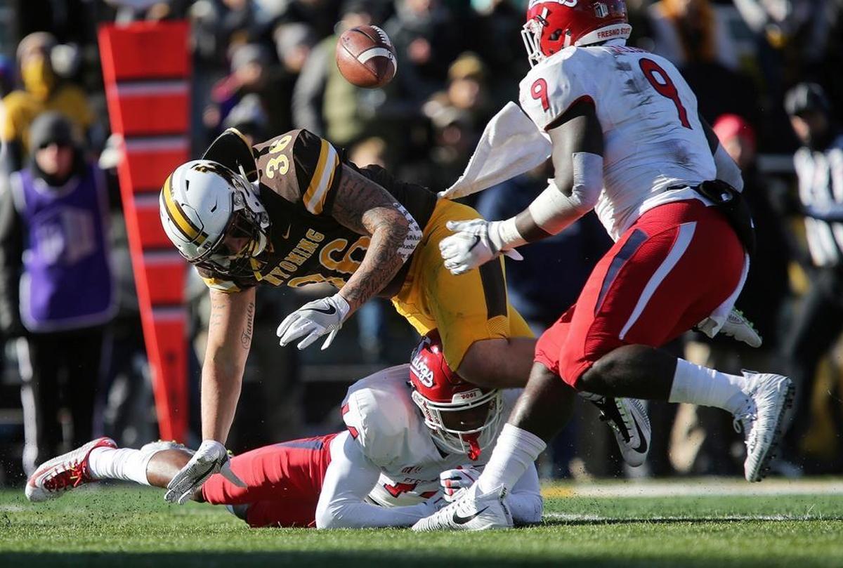 Wyoming fullback Drew Van Maanen (36) fumbles the ball while being tripped up by Fresno State defensive back Jaron Bryant (14) last Saturday at War Memorial Stadium in Laramie, Wyo.