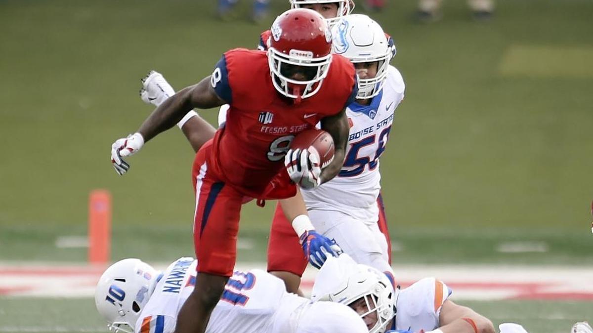 Fresno State’s Da’Mari Scott leaps over Boise State’s Kekoa Nawahine, bottom, during second-half action last Saturday in Fresno.